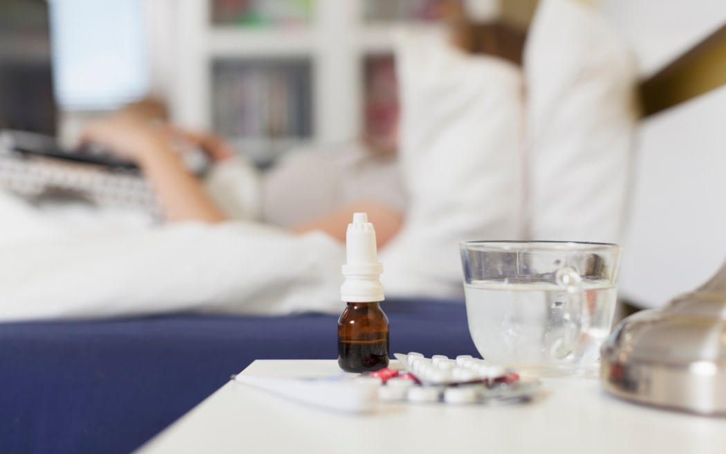 Medicines by bed of sick person.