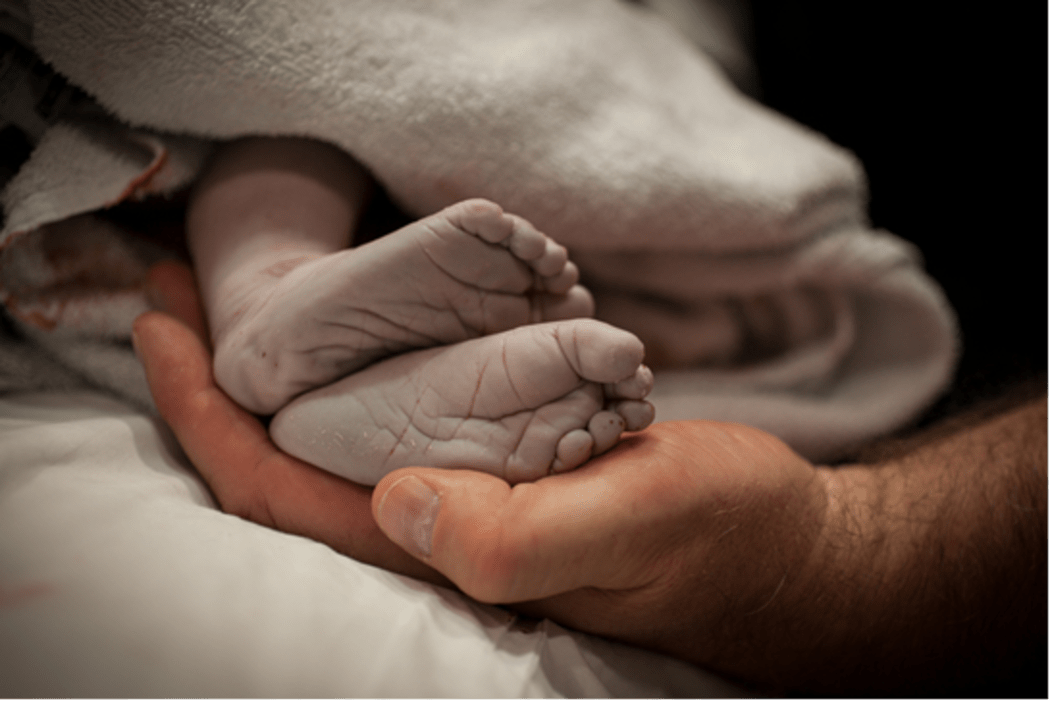 A photo of Noel Keenan holding his son Tanner's feet.