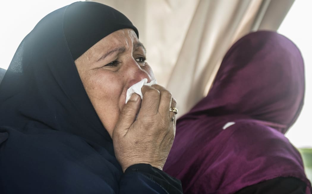 A relative of a passenger who was flying aboard an EgyptAir plane that vanished from radar en route from Paris to Cairo overnight cries as family members are transported by bus to a gathering point at Cairo airport.