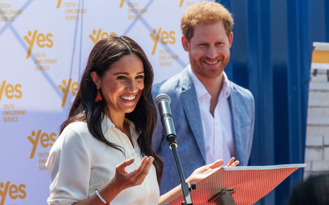 (FILES) In this file photo taken on October 02, 2019 Meghan, Duchess of Sussex(L), is watched by Britain's Prince Harry, Duke of Sussex(R) as  she delivers a speech in Johannesburg, on October 2, 2019.