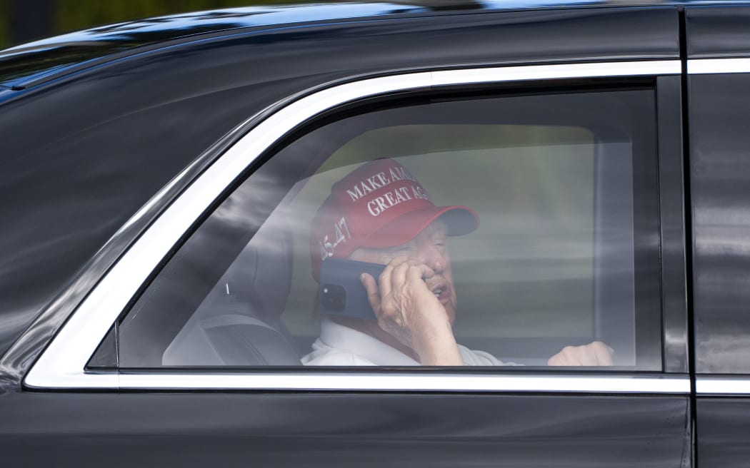 President Donald Trump talks on the phone as he arrives at the Trump International Golf Club on April 4, in West Palm Beach, Florida.
