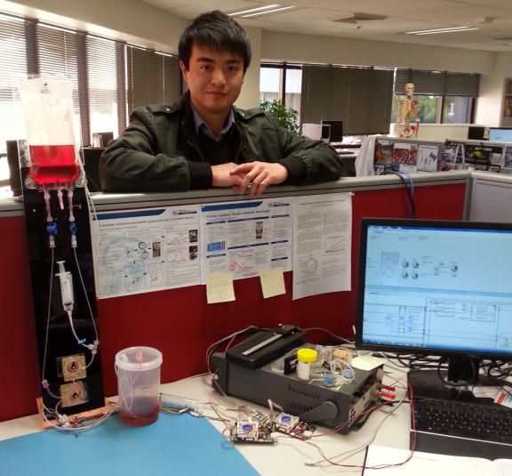 A photo of Dixon Leung with a prototype device to simulate a shunt and boost performance