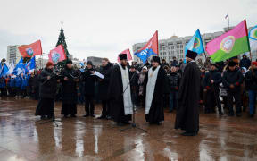 Mourners gather with priests to lay flowers in memory of more than 60 Russian soldiers that Russia says were killed in a Ukrainian strike on Russian-controlled territory, in Samara, on January 3, 2023.