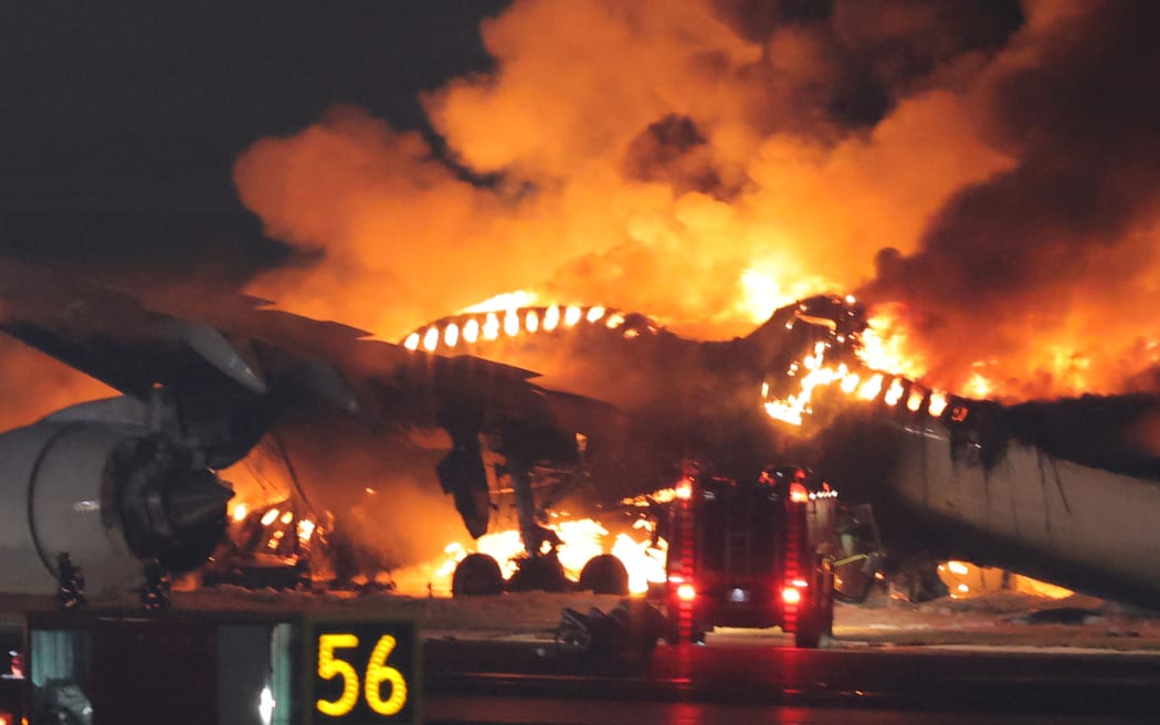 A Japan Airlines flight 156 catches fire on the C runway at Haneda Airport in Ota Ward, Tokyo on Jan.2nd, 2024, firefighting efforts are underway. The fire started on the aircraft just as it landed. Haneda Airport has blocked the runway. According to the airport authorities,  the plane caught fire from the rear of the fuselage almost as soon as it landed and the plane collided with a Japanese Coast Guard (JCG) aircraft. All 379 passengers and crew members of the Japan Airlines airplane managed to escape from the fire after a collision with a JCG aircraft, whose five of the JCG plane crew had died. ( The Yomiuri Shimbun ) (Photo by Ryoichiro Kida / Yomiuri / The Yomiuri Shimbun via AFP)