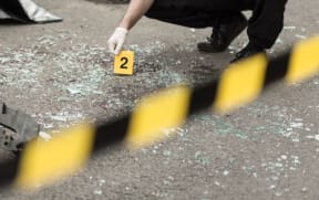 A policeman inspects a road after a crash.