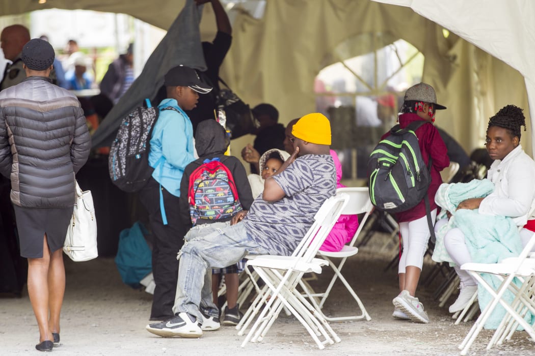 Refugees wait a processing centre after crossing the border into Quebec from the US