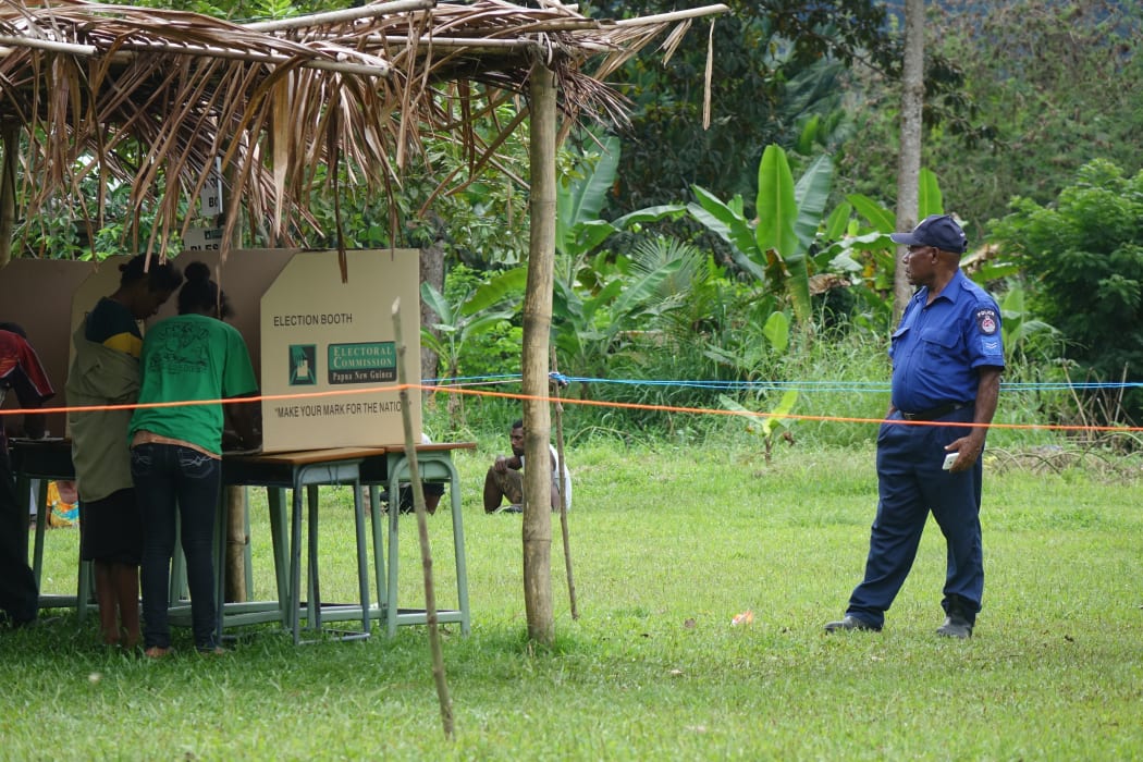 A police officer watches over polling in Papua New Guinea's election.