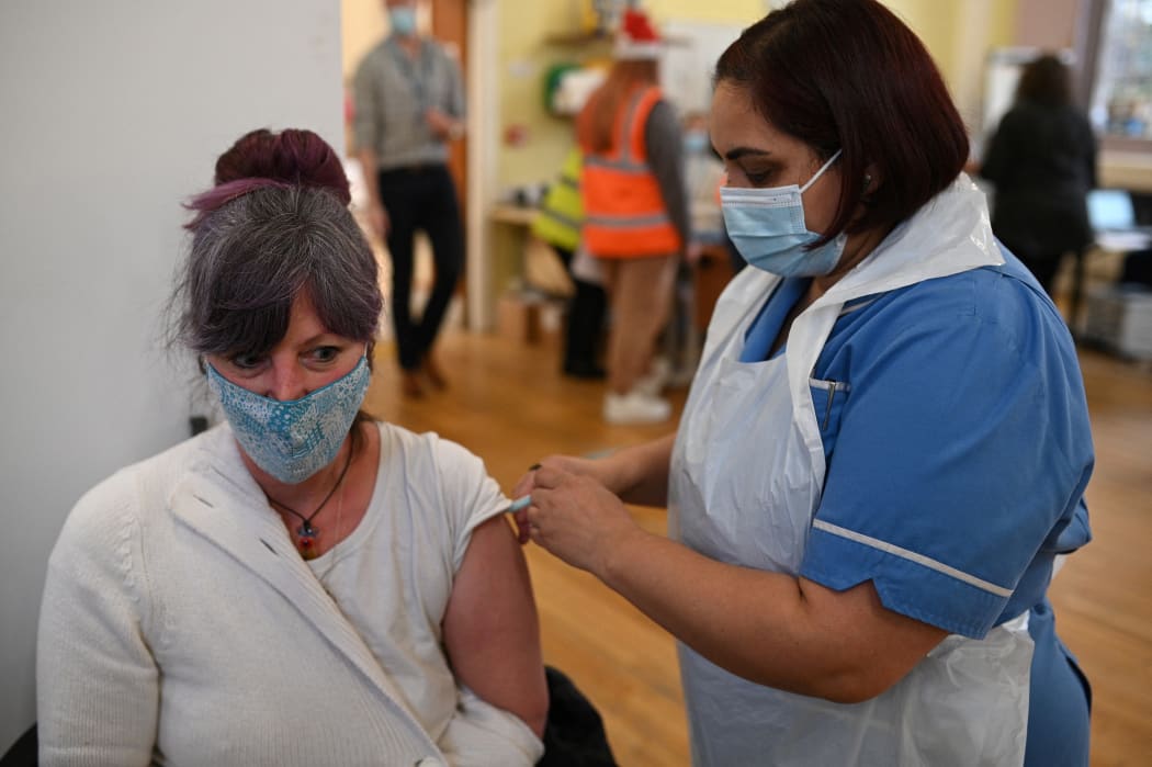 A woman receives a dose of the Moderna Covid-19 vaccine in Belper, Derbyshire, as the UK steps up its booster drive to fight Omicron.