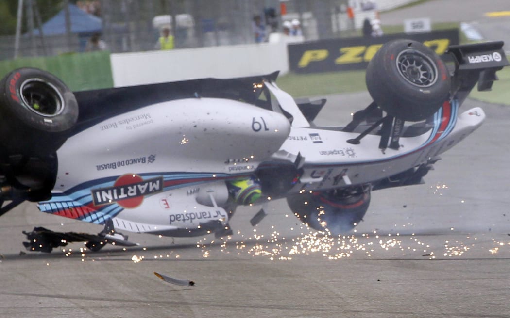 A Formula One car rolls after crashing.