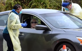 Health workers administer the Moderna COVID-19 vaccine to a couple in a car at a drive-thru vaccination event for residents 65 and older at Dewey O. Boster Park and Sports Complex on January 7, 2021 in Deltona, Florida.