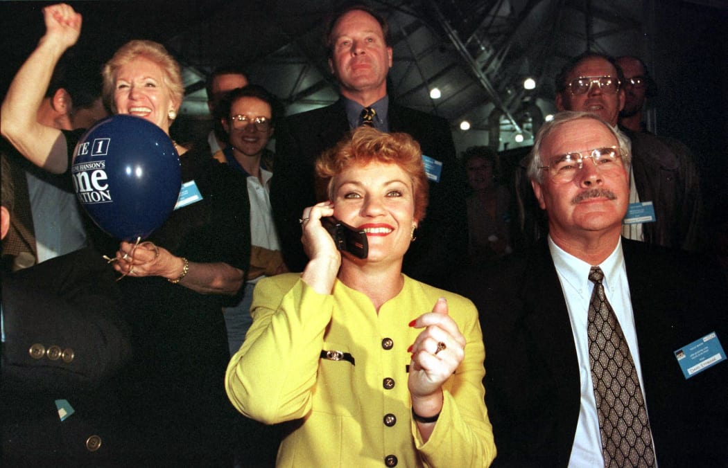 Picture dated 13 June show Anti-Asian MP Pauline Hanson (C) being congratulated by phone as One Nation national director David Ettridge (R) and supporters celebrate in the Brisbane tally room after their fledgling party captured 23 percent of the vote during the Queensland elections.