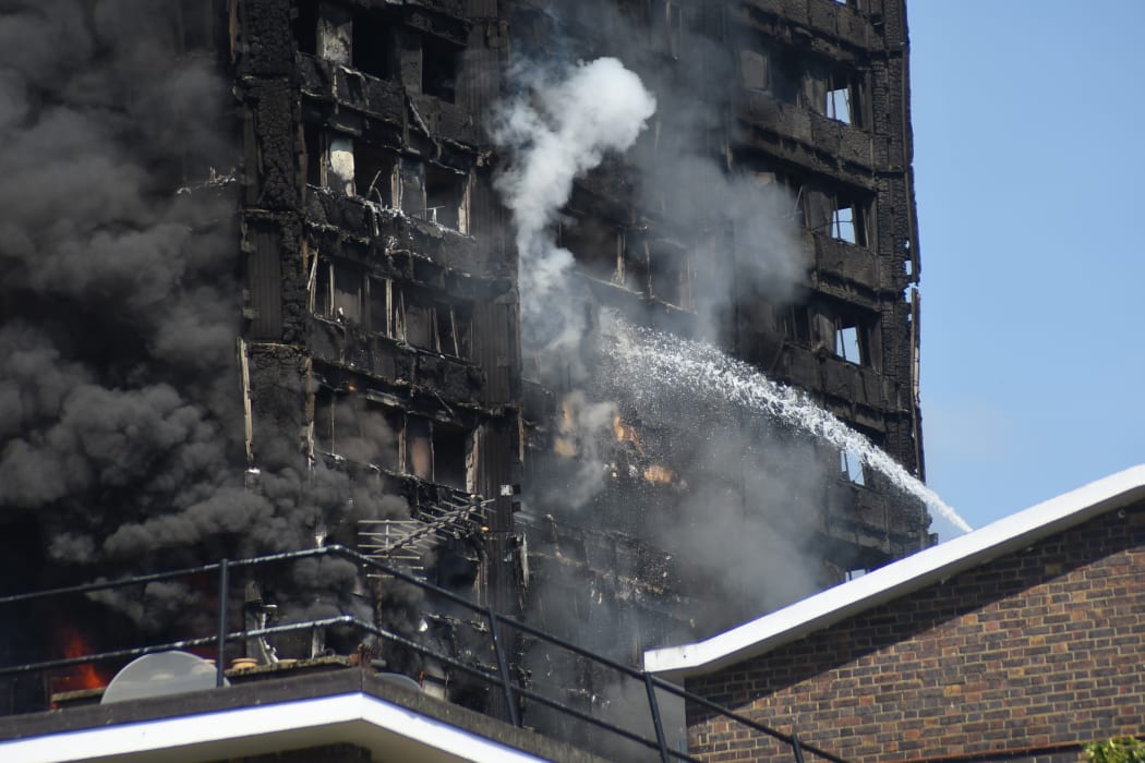 Smoke and flames billows from Grenfell Tower as firefighters attempt to control a blaze at a residential block of flats at Ladbroke Grove, London on 14 June, 2017.