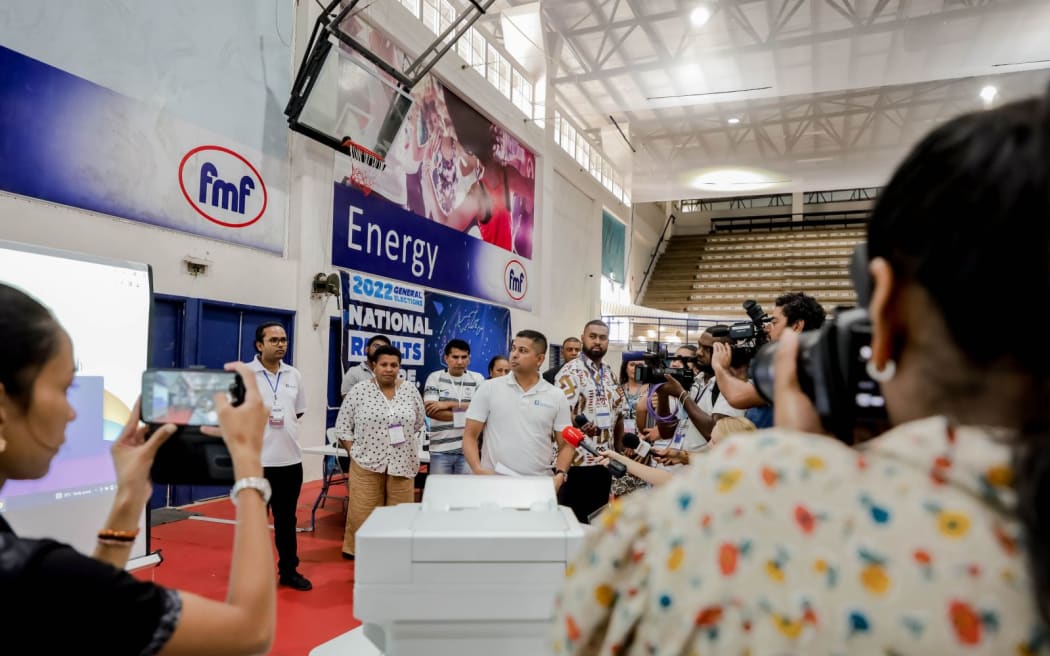 The supervisor of election, Mohammed Saneem, (centre) speaking to media at the results centre before the flushing of the provisional database. 15 December 2022