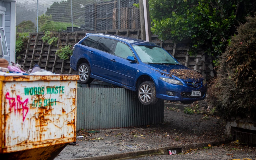 A car carried by floodwaters landed on top of a chest-high fence after Monday’s torrential rain in Wellington.