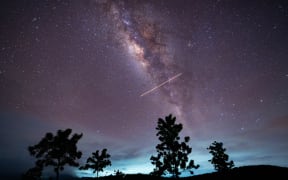 A flight-illuminated path and the Milky Way are appearing in the night sky during the Eta Aquarids meteor shower, which is peaking in Ratnapura, Sri Lanka, on May 5, 2024. The Eta Aquarids Meteor Shower is an annual event caused by Earth passing through debris left behind by Halley's Comet. Named after the constellation Aquarius, these meteors are streaking across the sky at high speeds, creating a dazzling display of shooting stars. Best observed in the predawn hours away from city lights, it is a mesmerizing celestial event cherished by skywatchers worldwide. (Photo by Thilina Kaluthotage/NurPhoto) (Photo by Thilina Kaluthotage / NurPhoto / NurPhoto via AFP)