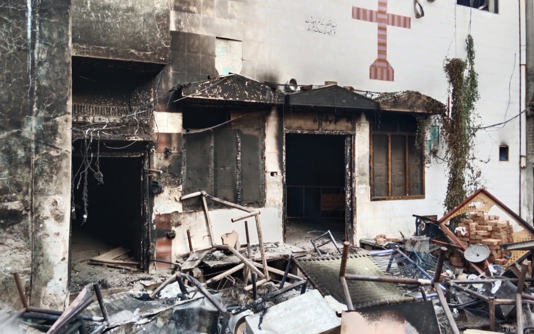 View of a burnt church on the outskirts of Faisalabad on August 16, 2023, following an attack by Muslim men after a Christian family was accused of blasphemy. Hundreds of Muslim men set fire to four churches and vandalised a cemetery during a rampage in eastern Pakistan on August 16, officials said, after a Christian family was accused of blasphemy. (Photo by Ghazanfar MAJID / AFP)