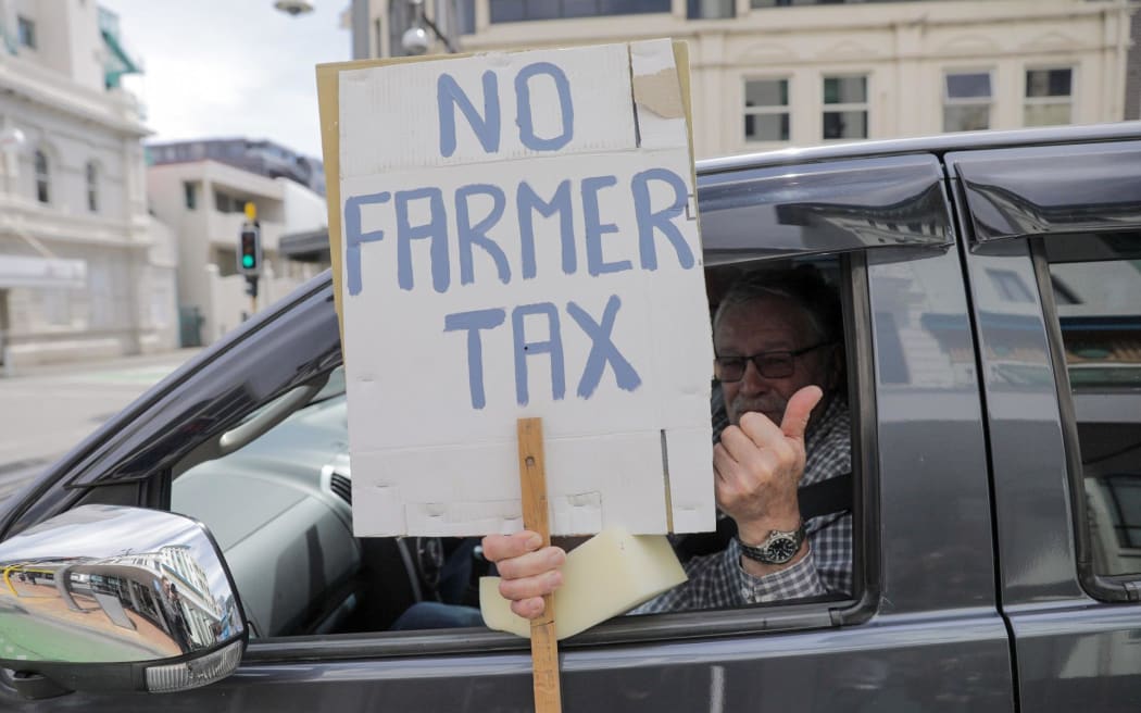 A member of the Groundswell protest holds a sign calling for government to drop its ute tax in Wellington on 20 October 2022.