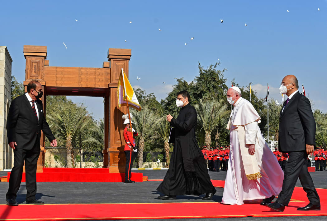 Pope Francis walks alongside Iraqi President Barham Saleh (right) during a welcome ceremony at the presidential palace in Baghdad on 5 March.