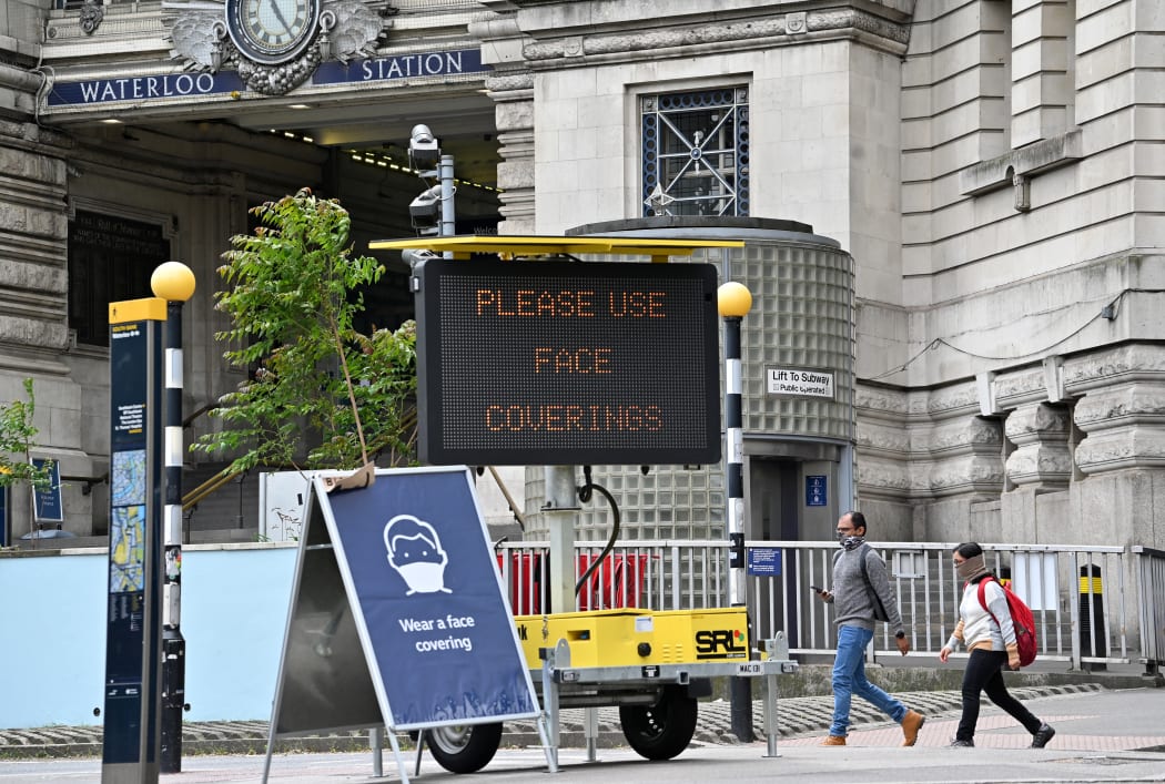 A sign tells passengers to 'wear a face covering' at Waterloo train station in central London during the Covid-19 pandemic