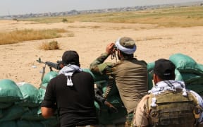 Iraqi Kurdish Peshmerga forces and al-Hashd al-Shaabi factions hold a position, about 250 km north of Ramadi, on 18 April.