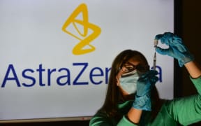 An illustrative image of a person holding a medical syringe and a vaccine vial in front of the Astra Zeneca logo displayed on a screen.
On Thursday, October 21, 2021, in Edmonton, Alberta, Canada.