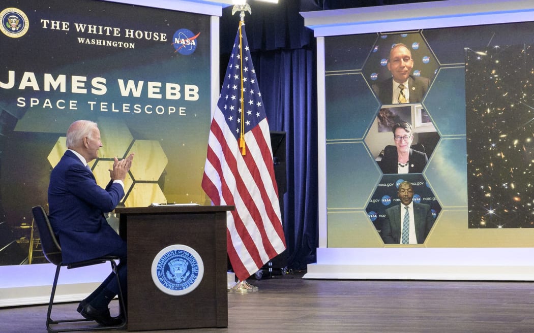 In this NASA handout image US President Joe Biden previews the first full-color image from NASA’s James Webb Space Telescope, the highest-resolution image of the infrared universe in history, on July 11, 2022, in the South Court Auditorium in the Eisenhower Executive Office Building on the White House complex in Washington. - Humanity's view of the distant cosmos will never be the same.
The James Webb Space Telescope, the most powerful to be placed in orbit, has revealed the clearest image to date of the early universe, going back 13 billion years, NASA said Monday.
The stunning shot, released in a White House briefing by President Joe Biden, is overflowing with thousands of galaxies and features some of the faintest objects observed, colorized in blue, orange and white tones. (Photo by Bill INGALLS / NASA / AFP) / RESTRICTED TO EDITORIAL USE - MANDATORY CREDIT "AFP PHOTO / NASA /...
