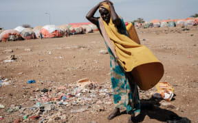 (FILES) In this file photo taken on February 13, 2022 A woman carries a water container at a camp for internally displaced persons (IDPs) in Baidoa, Somalia. - UN humanitarian chief Martin Griffiths warned on September 5, 2022 that Somalia was "at the door of famine" after being hit by four failed rainy seasons that has caused a devastating drought.
"Famine is at the door and we are receiving a final warning," Griffiths said at a press conference in Mogadishu, saying famine was likely in two areas in south central Somalia between October and December this year. (Photo by YASUYOSHI CHIBA / AFP)