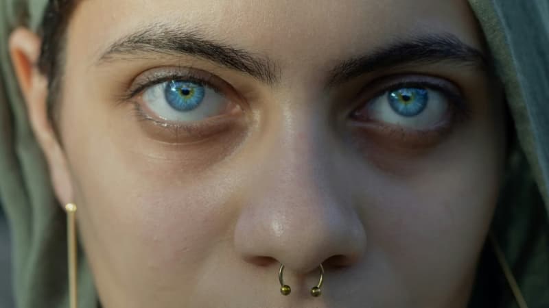 A close-up of a woman's pale blue eyes.