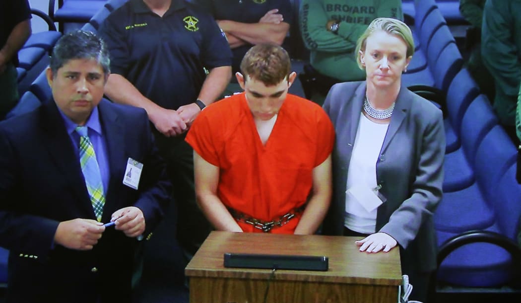 (FILES) In this file still photo taken from a tv screen on February 15, 2018, Assistant Public Defender Hector Romero (L) and Public Defender Melisa McNeill (R), appear at a Broward County Court House hearing for Nikolas cruz
