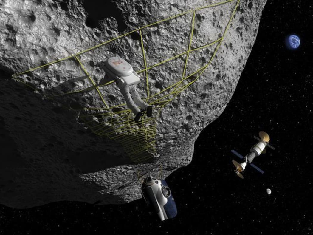 In this artist's concept an astronaut performs a tethering maneuver at an asteroid.