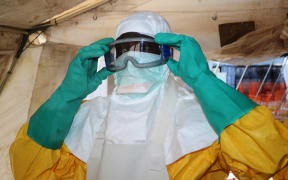 A member of Doctors Without Borders (MSF) putting on protective gear at Donka Hospital in Conakry, where people infected with the Ebola virus are being treated in June, 2014.