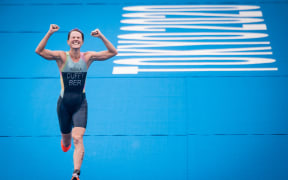 Bermuda's Flora Duffy celebrates as she crosses the finish line to win the women's individual triathlon competition during the Tokyo 2020 Olympic Games on 27 July, 2021.