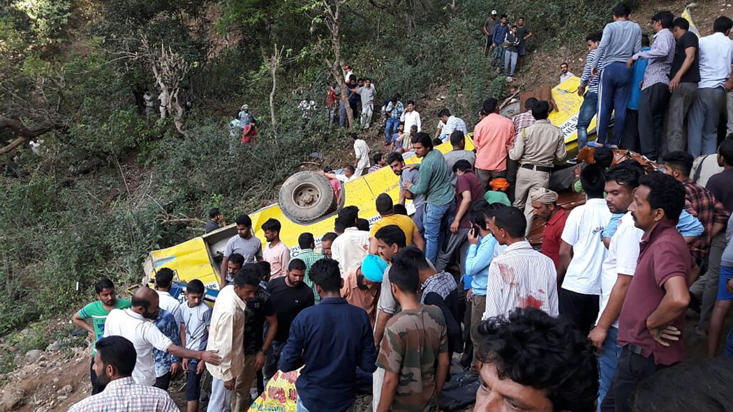 People helping to rescue injured after a private school bus falls into a deep gorge in Nurpur, Kangra district.