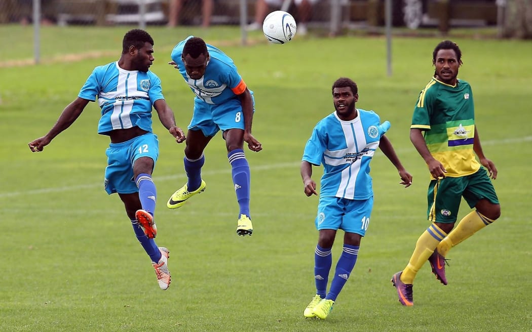 Malampa Revivors duo Marcelin Piloe and John Alick try to clear the ball against Lae City Dwellers.