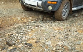 Car wheel in dirty ground road.