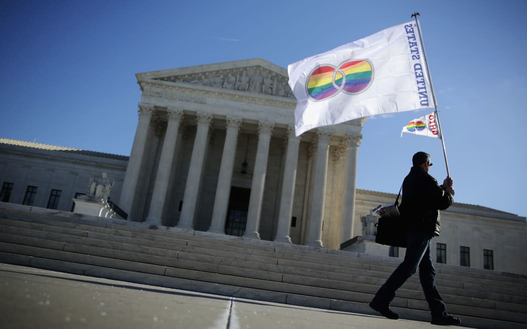 An activist from Equality Beyond Gender holds a marriage pride flag outside the U.S. Supreme Court January 2015.
