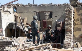 Afghan policemen at the site of the suicide bombing attack.