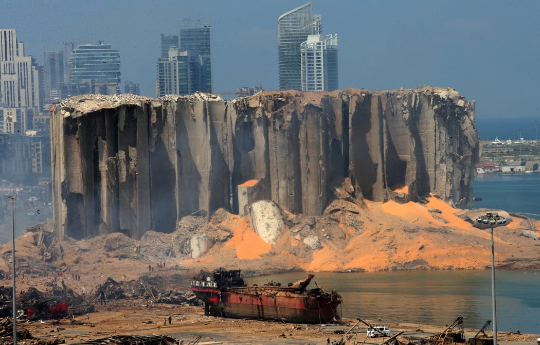 The damaged grain silo and a burnt boat at Beirut's harbour a day after powerful twin explosions tore through Lebanon's capital from the ignition of a huge depot of ammonium nitrate at the city's main port.