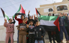 Palestinians gather to celebrate in the streets of Rafah, Gaza Strip, on January 19, 2025. They return to their homes after over a year of conflict, following a ceasefire agreement between Israel and Hamas. (Photo by Youssef Alzanoun / Middle East Images / Middle East Images via AFP)