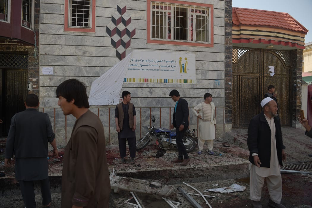 Afghan residents inspect the site of a suicide bombing outside a voter registration centre in Kabul on April 22, 2018