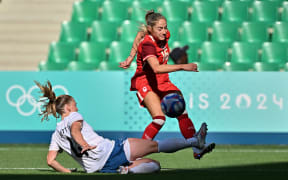 Canada forward Nichelle Prince beats CJ Bott of New Zealand for the ball in the Football Ferns' opening match at the Paris Olympics.