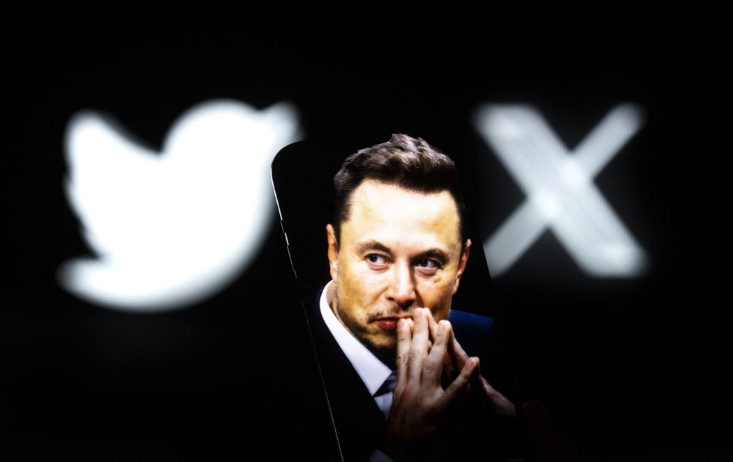An effigy of Elon Musk is seen on a mobile device with the X and Twitter lgoso in the background in this photo illustration on 23 July, 2023 in Warsaw, Poland. (Photo by Jaap Arriens/NurPhoto) (Photo by Jaap Arriens / NurPhoto / NurPhoto via AFP)