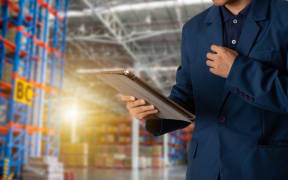 Businessman manager using tablet check and control for workers with Modern Trade warehouse logistics. Industry 4.0 concept