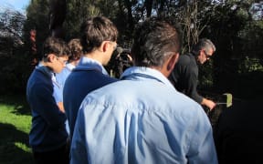 Taratahi skills tutor James Doyle demonstrates how to tie a termination knot on a fence, watched by students.