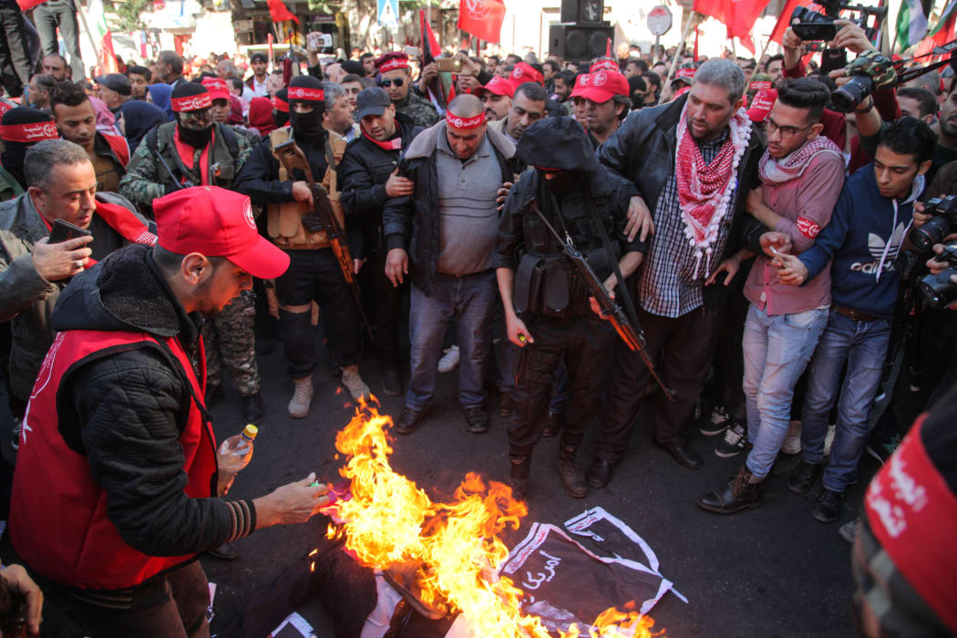 Protesters burn an effigy of US President Donald Trump as Palestinian Popular Front for the Liberation of Palestine supporters rally in Gaza City to protest against US President Donald Trump's decision to recognize Jerusalem as Israel's capital.