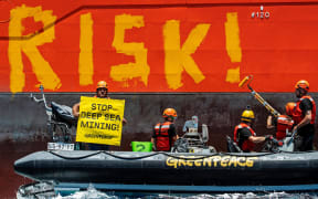 Greenpeace International activists paint the word 'RISK!' on the starboard side of Normand Energy, a vessel chartered by the Belgian company Global Sea Mineral Resources (GSR).