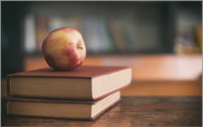 Apple sitting on books