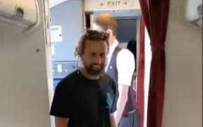 Andre Rerekura re-entering the plane after taking a non-venomous Stimson's python off the aircraft.