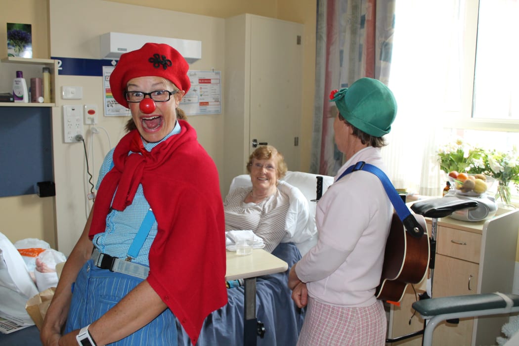 A photo of clown doctors sharing a joke with Phillipa Scott at Princess Margaret Hospital