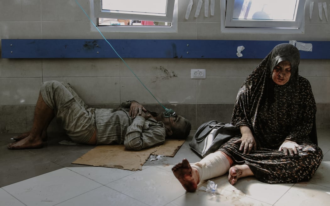 Injured individuals, including children, are being transported to the overwhelmed Al-Shifa Hospital in Gaza City, where doctors face significant challenges in providing care due to its current capacity.